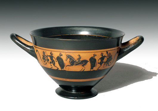 >A horse and rider are flanked by two draped figures and two satyrs on either side of this Attic black-figure skyphos, circa 530 B.C. Excluding the handles, it measures 4 7/8 inches in diameter and is estimated at $6,500-$8,000. Image courtesy of Artemis Gallery Live.com.